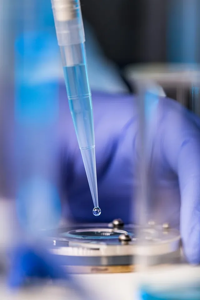Close-up of a pipette dispensing a liquid drop onto a lab instrument, representing Bacteriological Chemical Analyses.